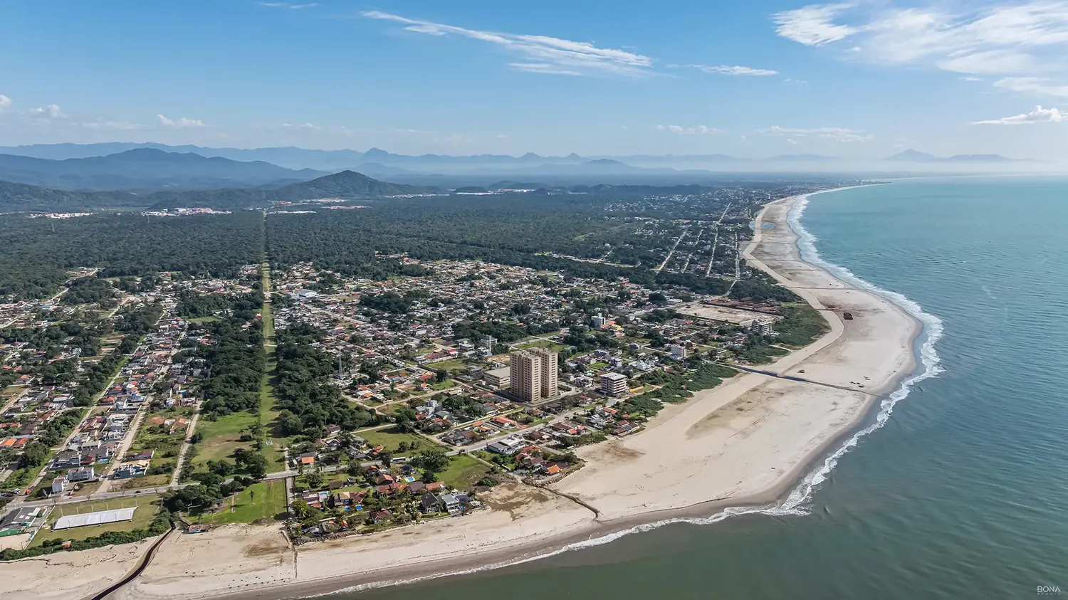 Vista aérea da orla de Itapoá, com a praia e a serra ao fundo